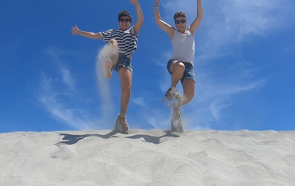 dos chicas saltando en la arena